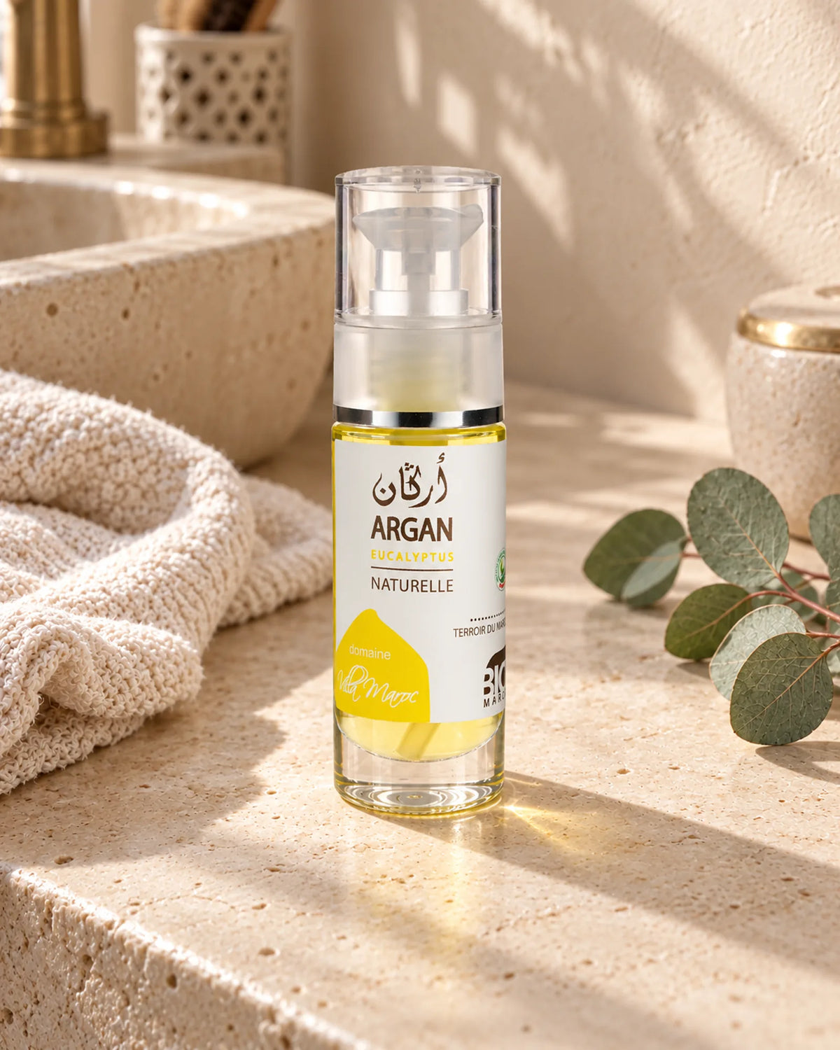 Huile d'Argan et d'Eucalyptus 30 ml — vue de trois quarts dans une salle de bain marocaine à la lumière naturelle.