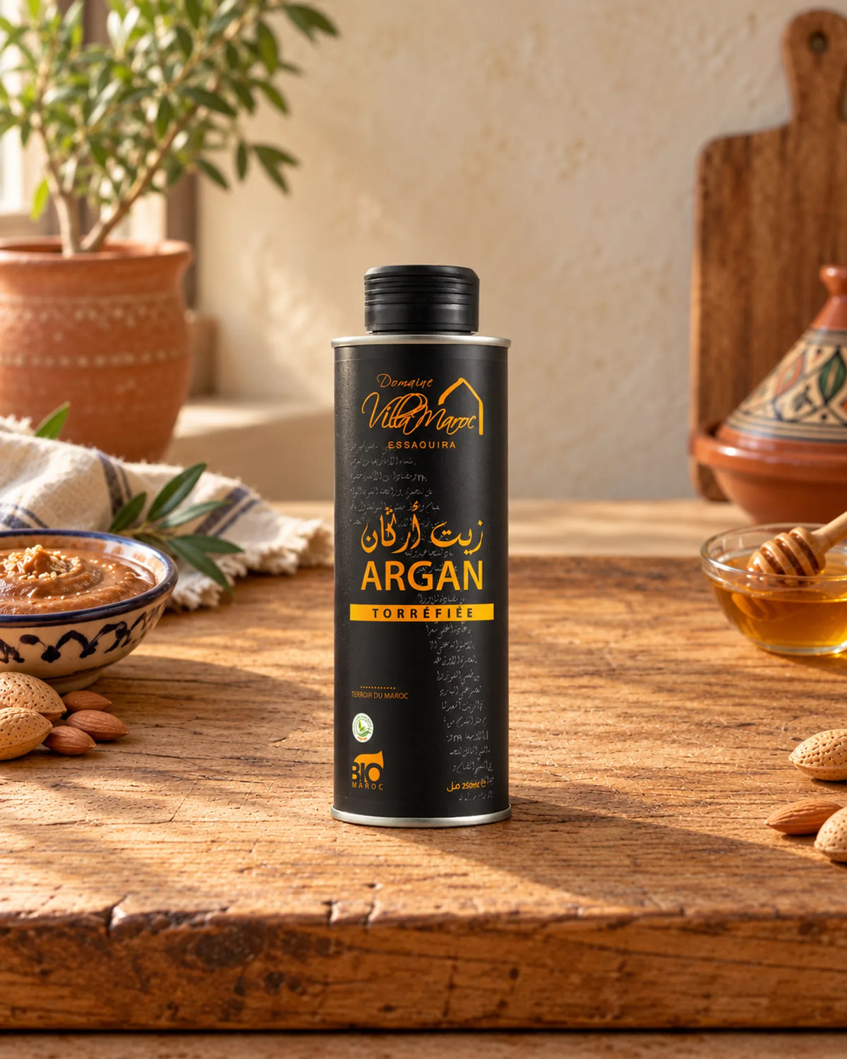 زيت الأركان المحمّص للطبخ 250 مل على لوح خشبي مع الأملو واللوز والعسل