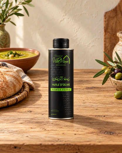 Huile d'Olive Extra Vierge 250ml sur un comptoir en bois, avec du khobz, de la bissara et une branche d’olivier.