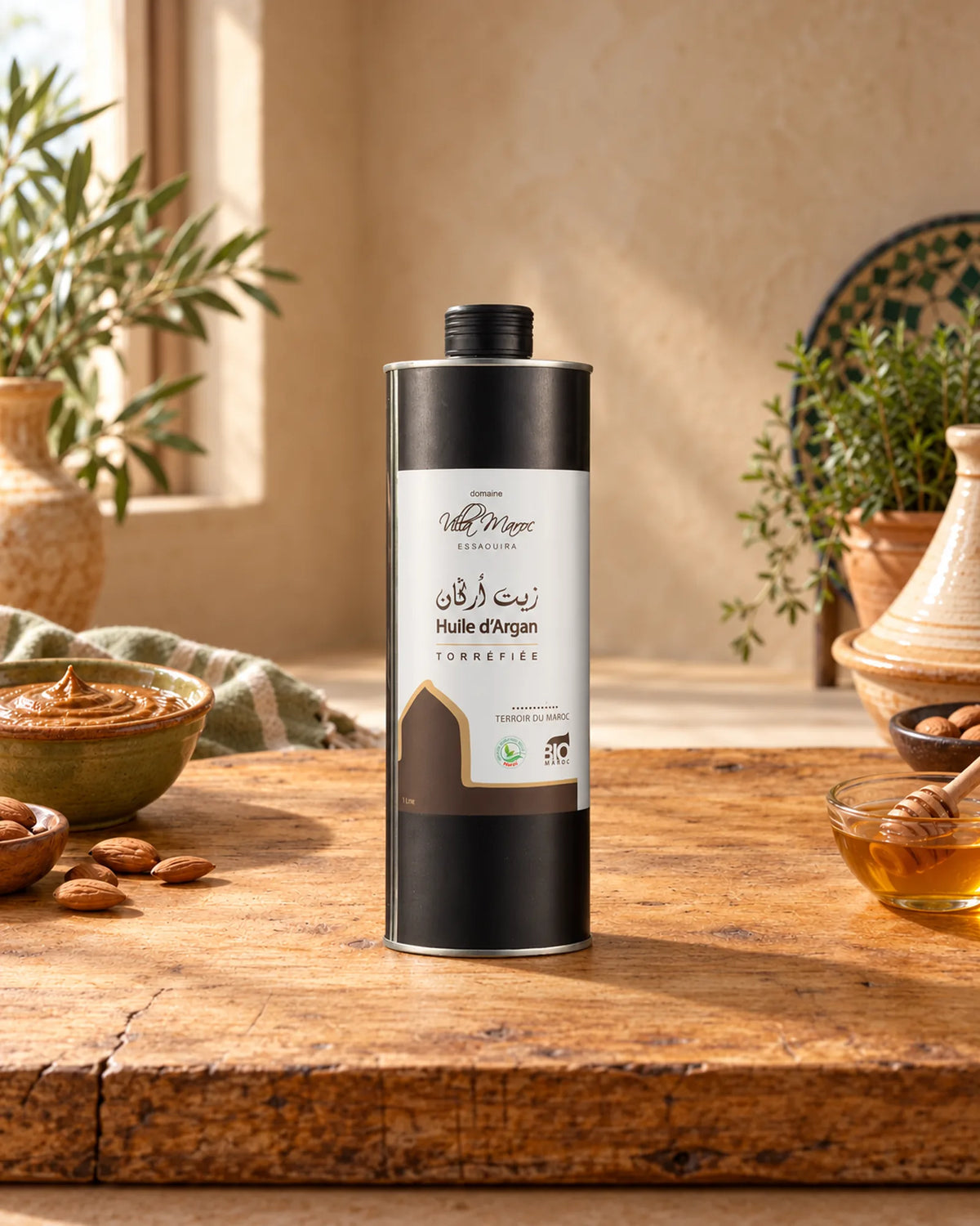 زيت الأركان المحمّص للطبخ 1 لتر على لوح خشبي مع الأملو واللوز والعسل