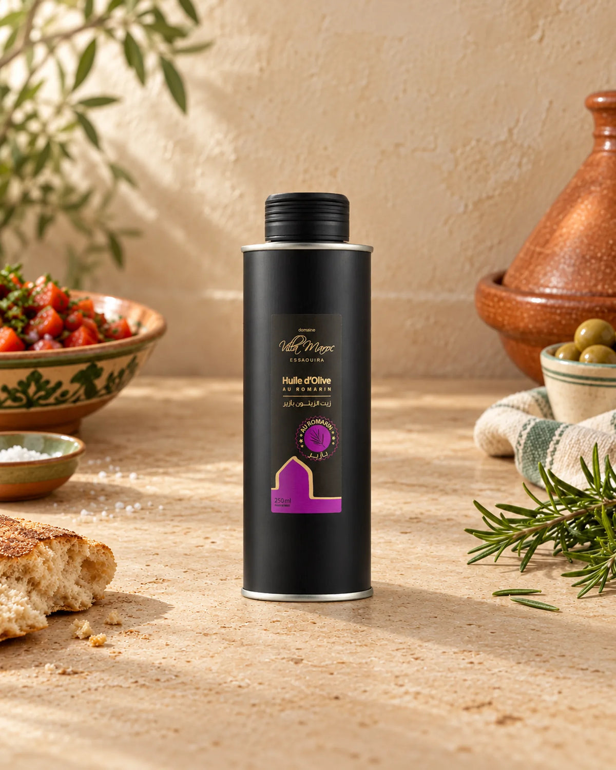 Huile d'Olive au Romarin 250ml sur un comptoir marocain en tadelakt, avec du romarin frais et du khobz.