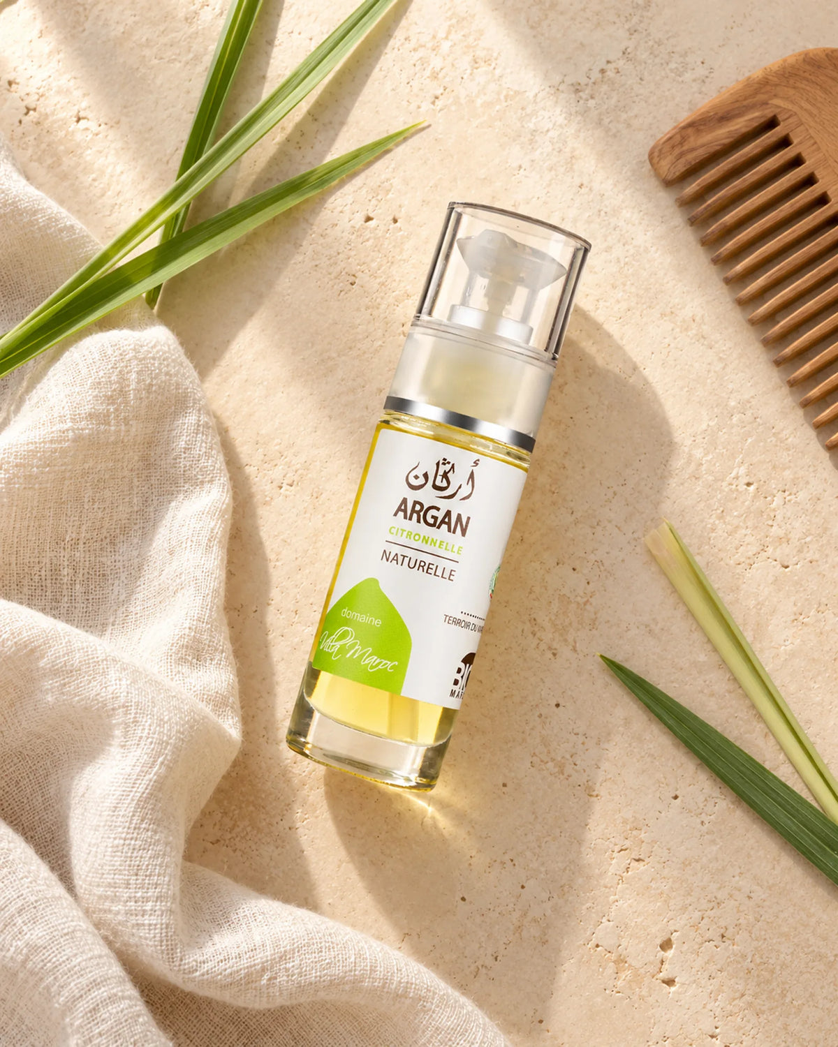 Huile d'Argan à la Citronnelle 30ml — vue du dessus dans une salle de bain marocaine à la lumière naturelle.